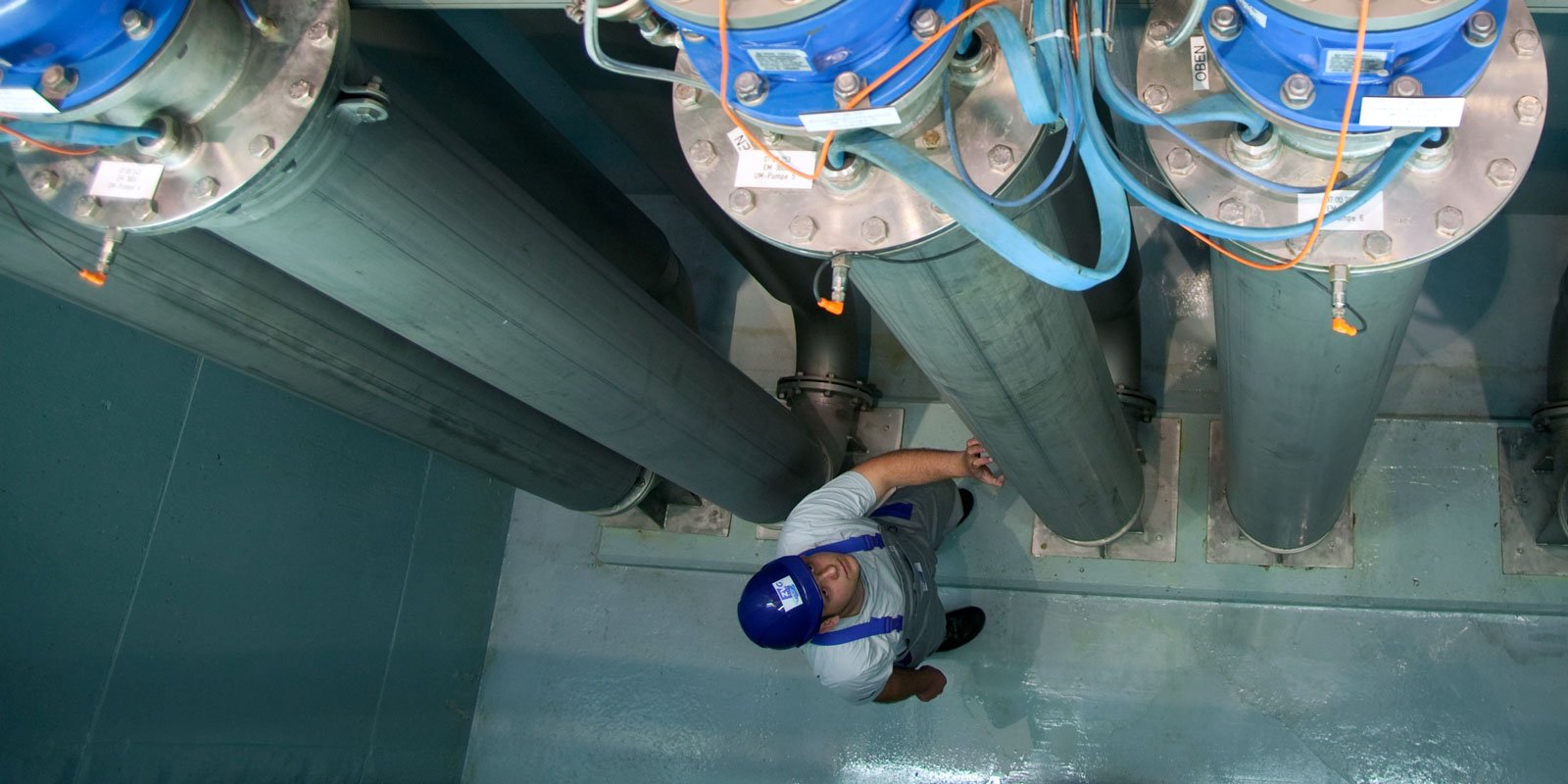 Mitarbeiter des Wasserwerks vor Rohrleitungen