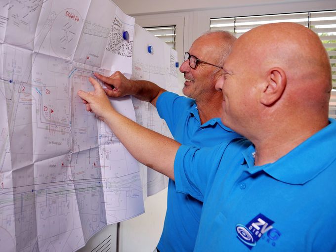 Teamarbeit im Wasserwerk – Mitarbeiter schauen auf Plan