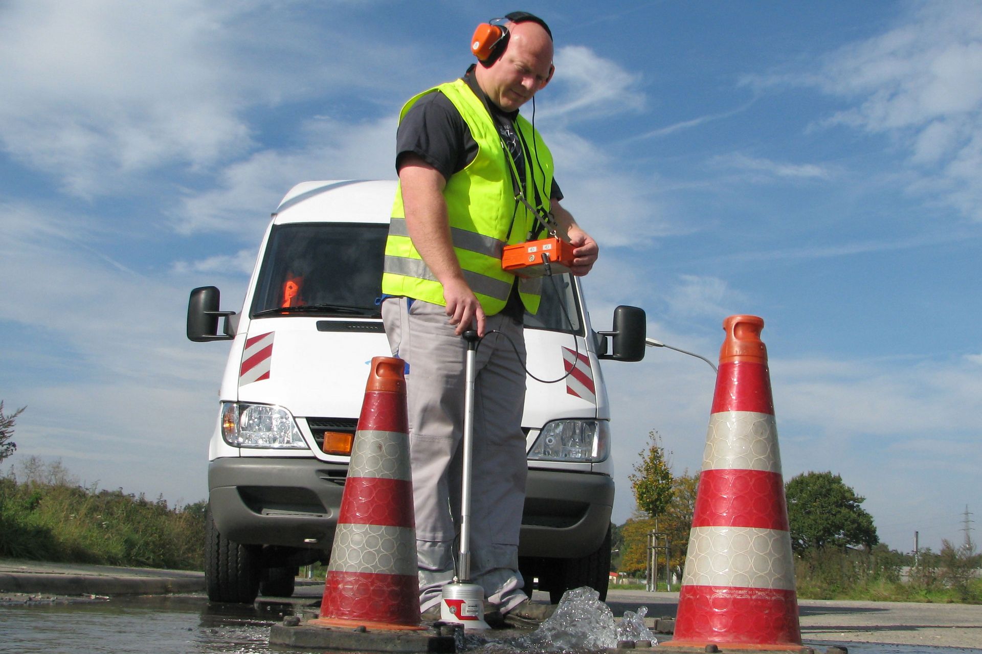 Mann beseitigt Rohrbruch im Straßenbereich